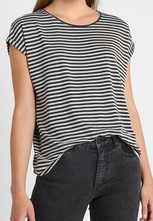 Femme portant un t-shirt à manches courtes à rayures horizontales noires et blanches, légèrement rentré dans un jean noir taille haute.