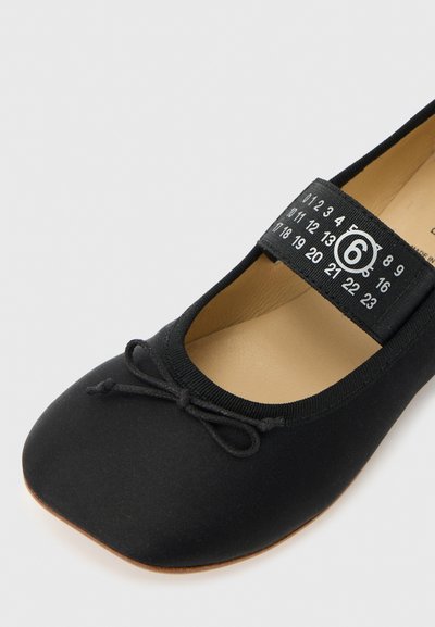 Μαύρο μπαλαρίνα με ελαστικό λουράκι, με κυκλωμένο μέγεθος 6, τετράγωνη μυτούλα, μικρή λεπτομέρεια φιόγκου και ταμπά εσωτερική σόλα.