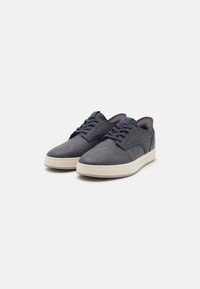 Dark grey suede sneakers with a smooth texture, lace-up front, and light-colored rubber sole. Features subtle stitching details.