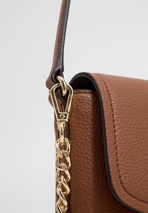 Sac à main en cuir texturé marron avec bordure noire, doté d'une bandoulière chaîne dorée fixée par un fermoir doré et une boucle en cuir marron.