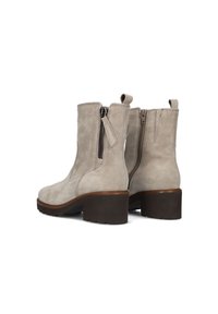 Lederen enkellaarsjes in lichtgrijs met een robuuste bruine hak. Voorzien van zijritsen en trekstrips voor gemakkelijk aan- en uittrekken. Tactiel materiaal en gestroomlijnd ontwerp.