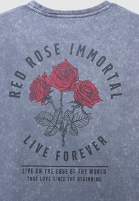 Trzy czerwone róże z liśćmi na szarym tle, otoczone tekstem: "Czerwona Róża Nieśmiertelna Żyj Wiecznie" oraz mniejszym tekstem poniżej.