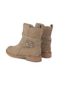 Botines de ante topo con un bajo tacón de madera, que cuentan con una correa ajustable con hebilla decorada con tachuelas plateadas. Cierre lateral con cremallera.
