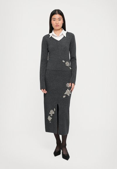 Pulover gri din tricot cu decolteu în V și mâneci lungi, asortat cu o fustă creion potrivită, cu o deschidere frontală și embellismente florale.