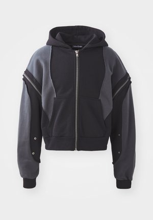 Hooded zip-up sweatshirt featuring a color-block design in black and gray. Made of soft fabric with ribbed cuffs and distinctive zippered accents.