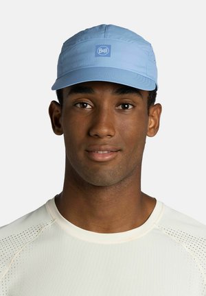Young man wearing light blue Buff cap and white athletic shirt, facing forward with a neutral expression on plain background.