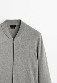 Szary sweter z prążkowanym kołnierzem i pełnym zamkiem błyskawicznym. Wykonany z miękkiego materiału, z długimi rękawami i minimalistycznym designem.