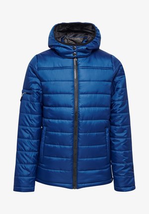 Giacca blu imbottita con cappuccio, chiusura frontale con zip e bottoni a pressione. Presenta cuciture orizzontali, tasche laterali e un logo sulla manica.