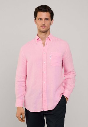 Helles rosa, langärmliges Hemd mit Knopfleiste aus Leinen, ausgestattet mit einer Brusttasche, einem Kragen und weißen Knöpfen, kombiniert mit dunklen Hosen.