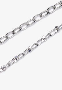 Two metal chains: one features elongated oval links, and the other has rectangular links with square accents. Both are silver-toned.