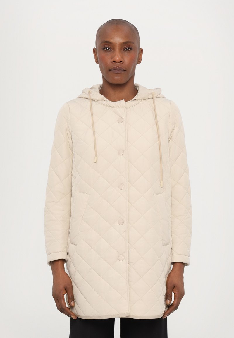 Beige quiltet jakke med hætte, der har trykknaplukning, to sidelommer og justerbare snore i hætten.