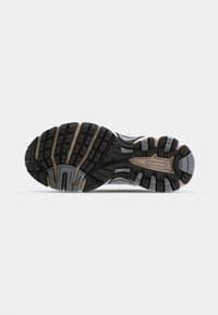Suola di scarpa sportiva nera e grigia con un motivo di battistrada ben evidente, design curvato; la gomma testurizzata offre aderenza. Presenta dettagli di branding sottili.