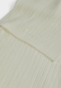 Campione di tessuto a maglia a coste color crema con una trama testurizzata, leggermente traslucida e un angolo piegato a strati.