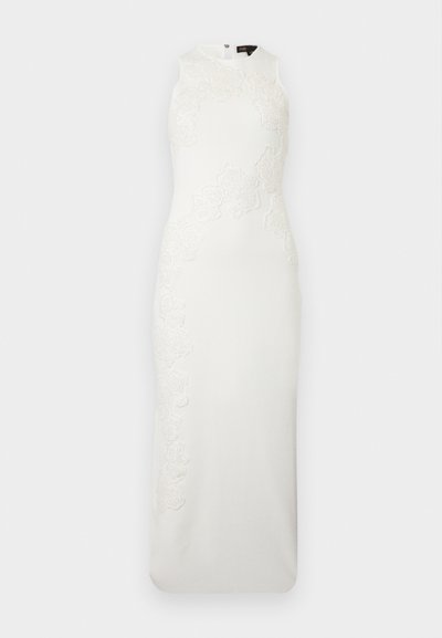 Λευκό εφαρμοστό φόρεμα χωρίς μανίκια με ψηλό λαιμό και διακριτικές λεπτομέρειες από δαντέλα με λουλούδια στο μπροστινό μέρος και στις πλευρές.