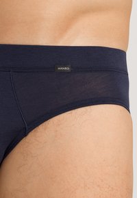 Navyblauwe herenslip van zacht materiaal, met een gladde tailleband en een klein 'HANRO' label. Strak gesneden voor comfort.