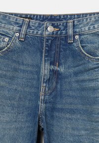 Jean en denim bleu à taille mi-haute, doté de cinq poches, de coutures contrastantes et d'une fermeture à bouton métallique. Texture lisse avec un léger effet délavé.
