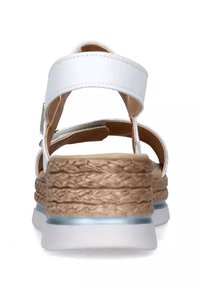 Infradito bianchi con tacco a zeppa in stile espadrille intrecciato marrone, dotati di una cinghietta alla caviglia e una finitura liscia e lucida.