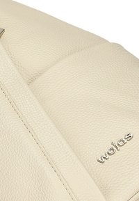 Krémová kožená kabelka s texturovaným povrchem, která disponuje vyraženým logem a jemnými detailními švy. Má strukturovaný tvar s hladkým povrchem.