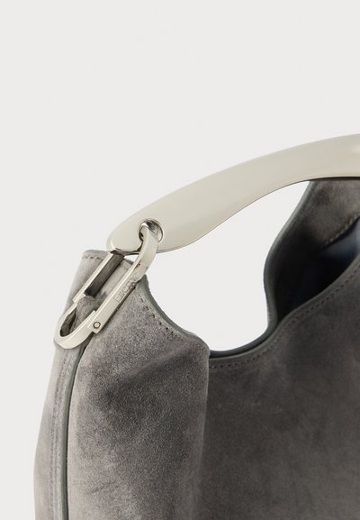 Grå ruskinds taske med en mat finish, præget af et glat cremefarvet håndtag, sølv hardware og en rund form med en lynlåsdetaile.