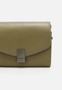 Clutch in pelle verde olive con forma rettangolare elegante. Presenta una chiusura in metallo argentato e dettagli cuciti lungo i bordi.