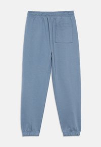 Ανοιχτό μπλε παντελόνι jogger από μαλακό ύφασμα, με ελαστική μέση, μανσέτες στους αστραγάλους και μία πίσω τσέπη.