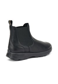 Botines de cuero negro hasta el tobillo con paneles laterales elásticos, tira de agarre y suela de goma texturizada. Acabado liso con detalles de diseño minimalistas.