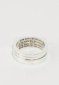 Silberring im gestapelten Design mit vier Bändern. Verfügt über glatte, polierte Oberflächen und die gravierte Aufschrift "MAPLE SILVER 925" im Inneren.