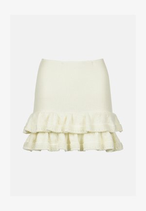 Jupe en tricot couleur crème avec un haut ajusté et un ourlet froncé texturé. Tissu riche et doux au design superposé.