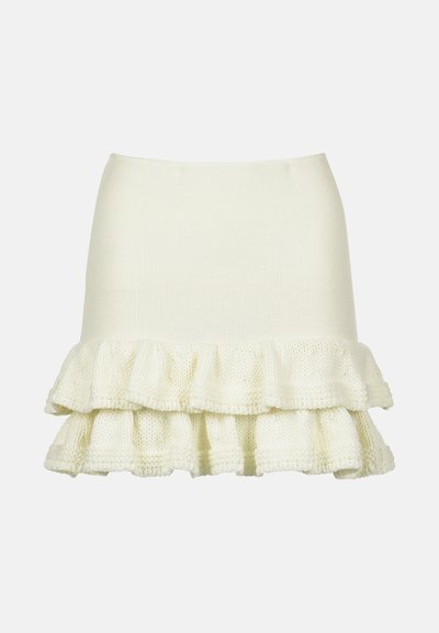 Pinti kreminės spalvos sijonas su prigludusia palaidine ir raukšlėta, tekstūruota apatine dalimi. Prabangus, minkštas audinys su sluoksniuota struktūra.