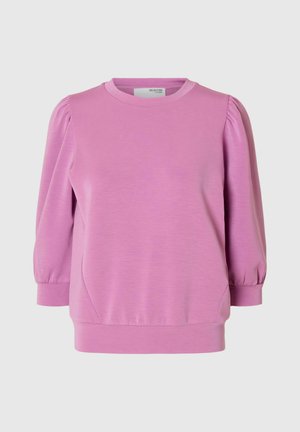 Ružičasti dukserica s okruglim izrezom, puf rukavima do tri četvrtine i opuštenim krojem. Napravljen od mekog, rastezljivog materijala s blagom teksturom.