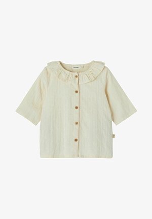 Blouse bébé à manches courtes couleur crème avec col volanté et cinq boutons en bois sur le devant.