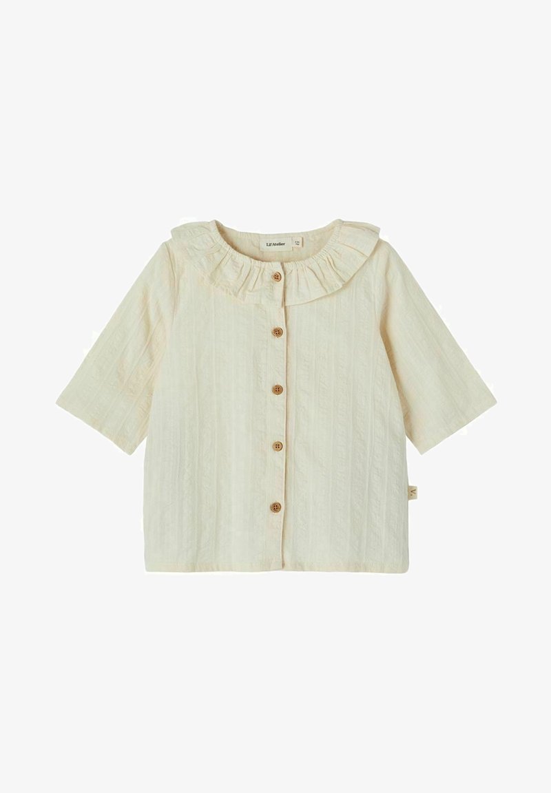 Blouse bébé à manches courtes couleur crème avec col volanté et cinq boutons en bois sur le devant.
