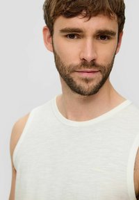 Weißes Tanktop mit leichter Struktur, rundem Ausschnitt und kleinem, in hellen Fäden auf der Brust gestickten s.Oliver-Logo.