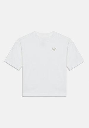 Biele tričko s krátkym rukávom a okrúhlym výstrihom s malým sivým logom "NB" na ľavej strane hrudníka, zobrazené na jednoduchom svetlom pozadí.