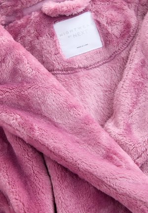 Vaaleanpunainen pehmeä polyesterikankaasta valmistettu yöpuku, jossa sisäpuolella saumattu merkki, jossa lukee "NIGHTWEAR by NEXT".