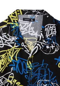 Camisetta nera a maniche corte con vivaci motivi di graffiti in blu, bianco e giallo. Include un colletto con incavo e bottoni neri.