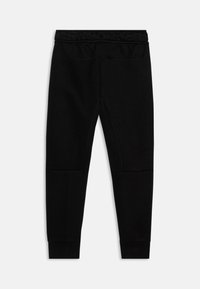 Pantaloni sportivi neri realizzati in un tessuto morbido. Sono dotati di una vita elastica, polsini alle caviglie e cuciture decorativa sui lati.