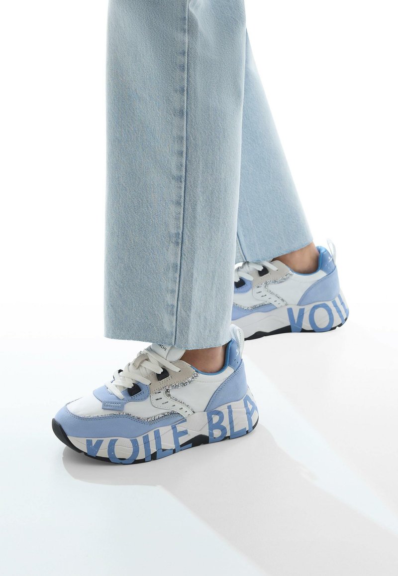 Le sneakers blu e bianchi presentano una combinazione di texture con accenti di glitter. La suola include un testo grande, "VOILE BLEU," che aumenta l'interesse visivo.