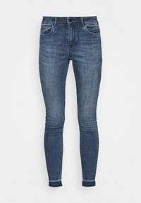 Pantalones vaqueros de mezclilla azul oscuro con corte ajustado, cinco bolsillos y un dobladillo ligeramente deshilachado. Presenta un diseño clásico y una textura suave.