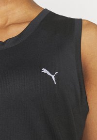 Černý bezramínkový top s ribbovanou texturou, s výstřihem do V a bílým logem Puma na levém prsu.