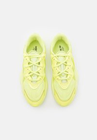 Limenvihreät urheilukengät, joissa on teksturoitu muotoilu, nauhat, pehmustettu kaulus ja logo kielen kohdalla. Kumipohja tarjoaa hyvän pidon.