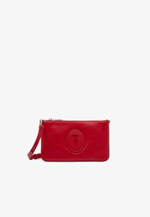 Piccola pochette rossa in pelle con cinturino da polso staccabile e logo ovale impresso sulla parte anteriore, chiusa con una cerniera superiore.