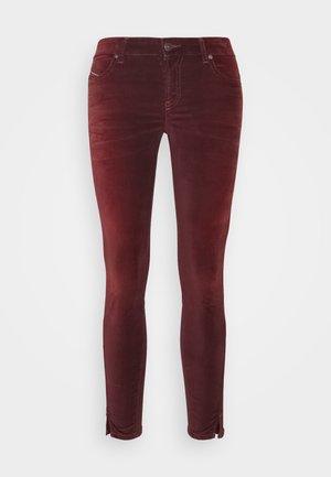 Pantalon skinny en velours côtelé bordeaux avec poches avant, fermeture par boutons et fentes aux chevilles sur les deux jambes.