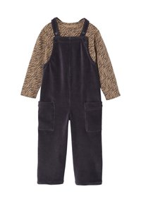 Corduroy overall in dark purple with adjustable straps, large front pockets, and a long-sleeved brown top with a zebra stripe pattern.