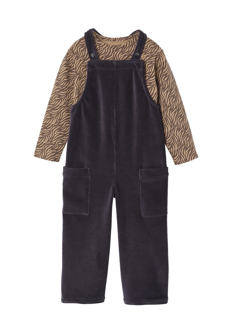 Corduroy overall in dark purple with adjustable straps, large front pockets, and a long-sleeved brown top with a zebra stripe pattern.