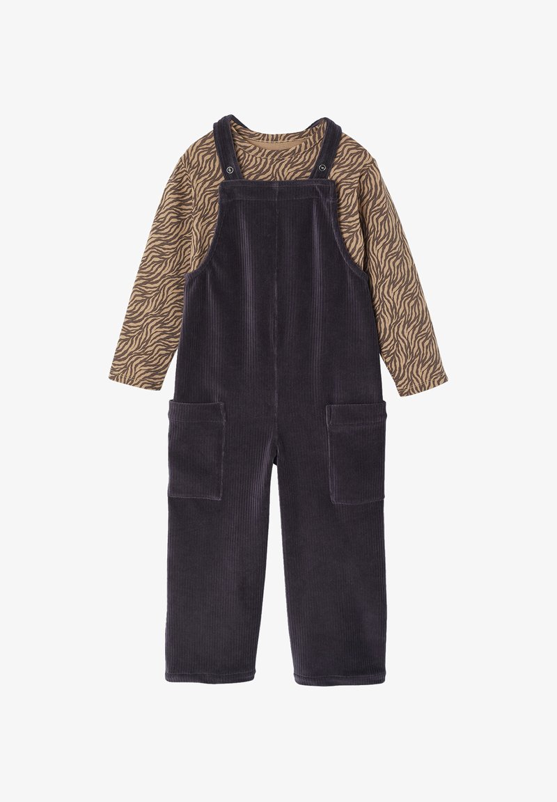 Corduroy overall in dark purple with adjustable straps, large front pockets, and a long-sleeved brown top with a zebra stripe pattern.
