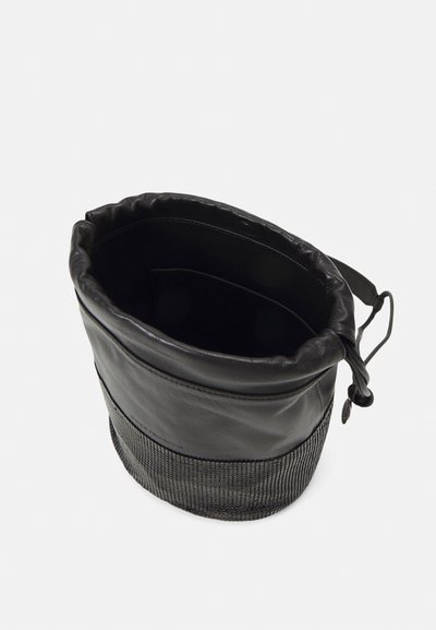 Geantă tip bucket neagră, cu o parte superioară din piele și o secțiune inferioară din plasă. Dispune de un sistem de închidere cu șnur și o mână laterală, oferind un contrast texturat.