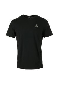 T-shirt noir à manches courtes en tissu doux avec un col rond. Présente un petit logo sur la poitrine et des panneaux latéraux texturés.