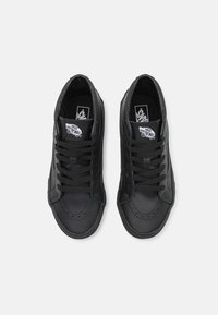 Sneaker alte in pelle nera con design stringato, colletto imbottito e logo Vans sulla linguetta. Texture liscia, punta arrotondata.