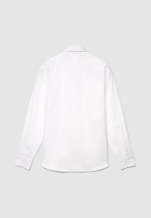 Chemise blanche à manches longues en coton, dotée d'un col classique, de poignets boutonnés et d'une texture lisse avec un détail de griffe dans le dos.